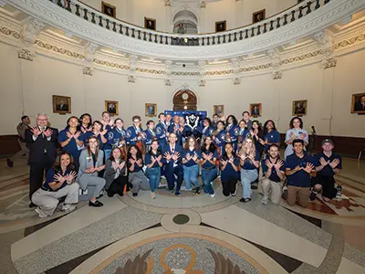 Students, faculty and staff gather in the Texas State Capitol’s rotunda.